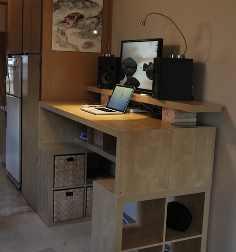 a desk with a laptop and speakers