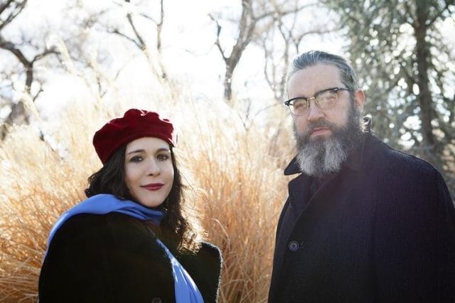 a man and woman standing next to each other outside