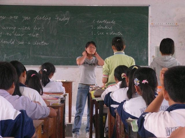a person standing in front of a classroom of students