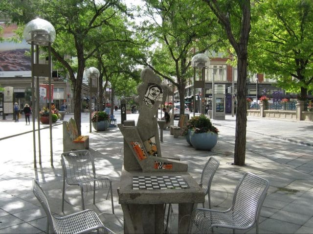 a statue of a person sitting at a table in a park