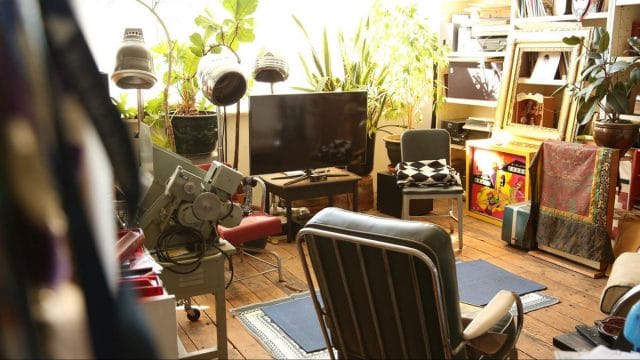 a living room with a tv and chairs