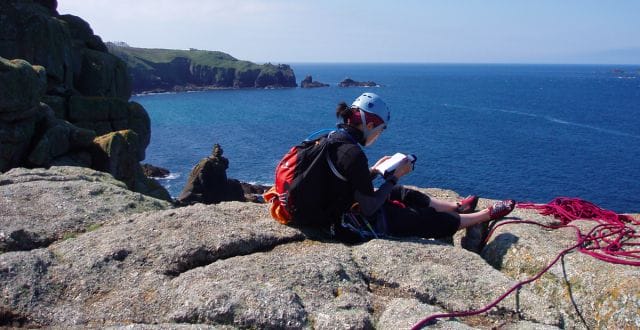 a person sitting on a rock by the water