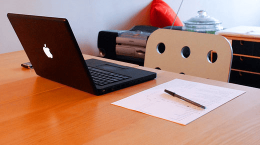 a laptop and a pen on a desk