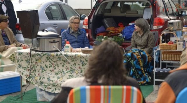 a group of people sitting at a table with food and drinks