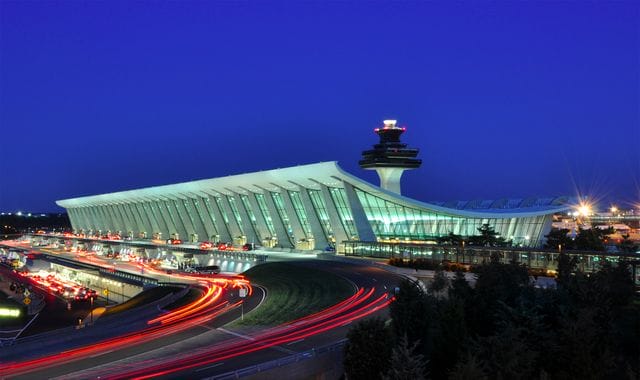 a stadium with a roof and a tower with lights at night