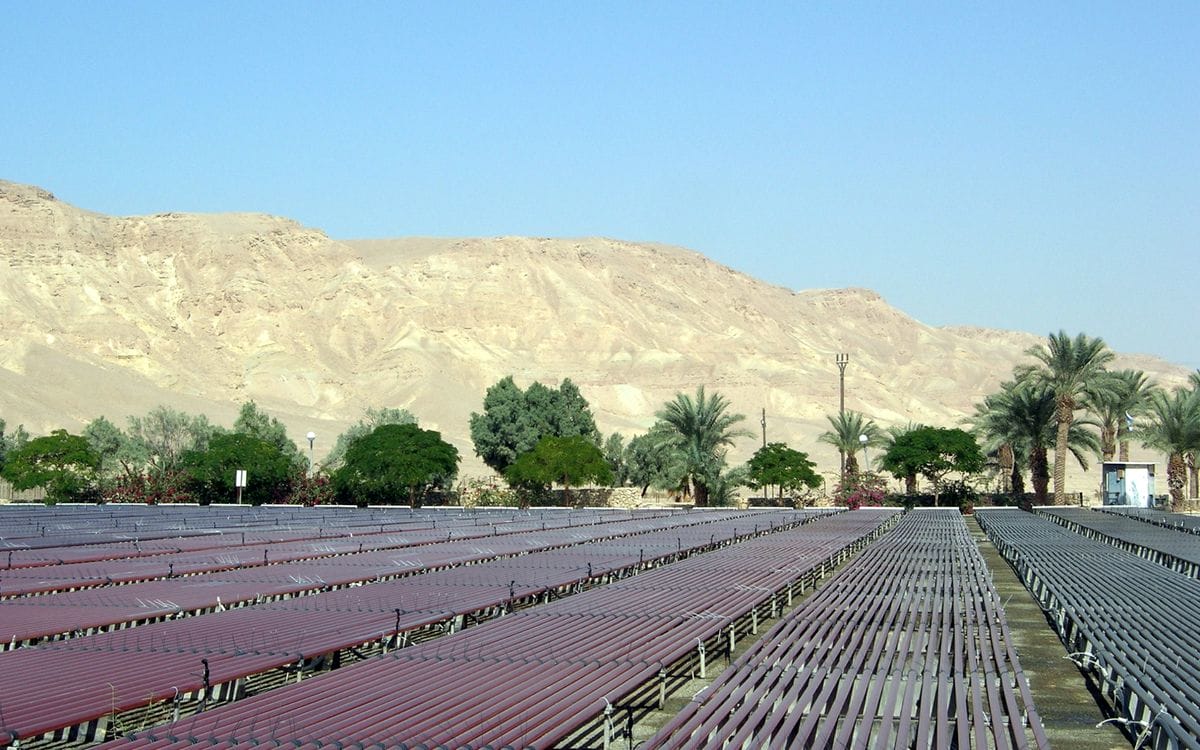 a large paved area with trees and a hill in the background
