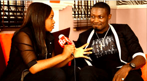 a man and woman sitting on a couch playing video games