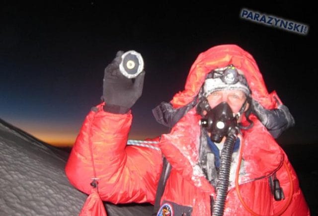 a person in a red coat and helmet holding a gun