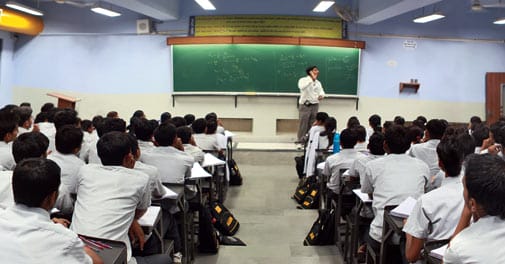 a person standing in front of a classroom of students
