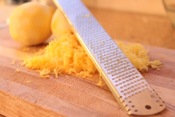 a knife with a yellow substance on a cutting board