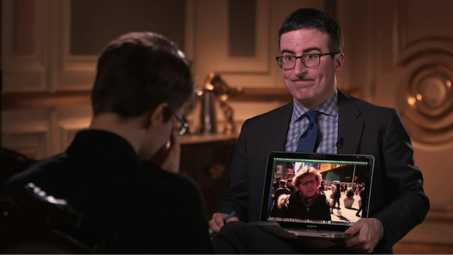 John Oliver holding a laptop