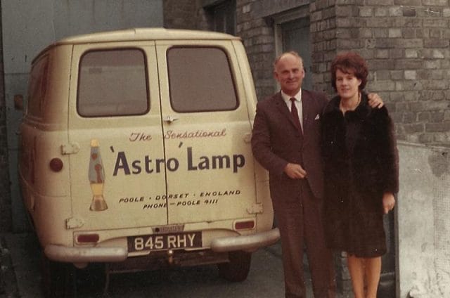 a man and woman standing next to a van