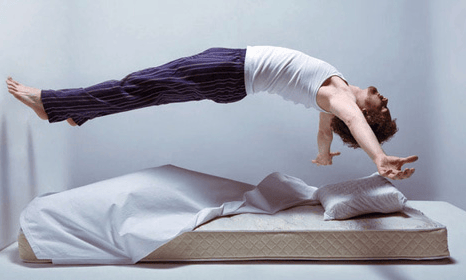 a person doing a handstand on a bed