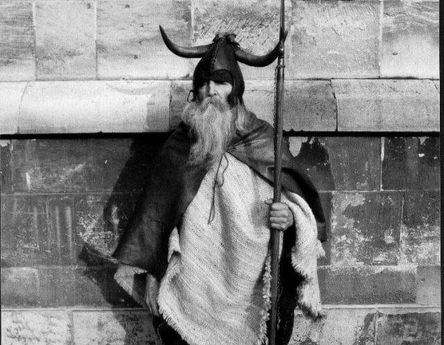 a person with a long beard and a long beard holding a sword