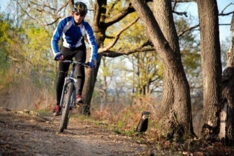 a man riding a bike on a trail in the woods