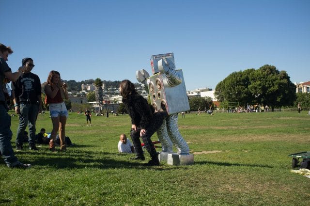 a group of people standing around a statue in a grassy area