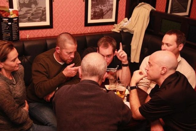 a group of people sitting around a table with drinks
