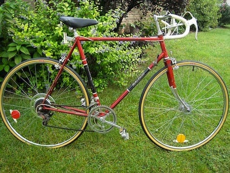 a red bicycle parked on grass