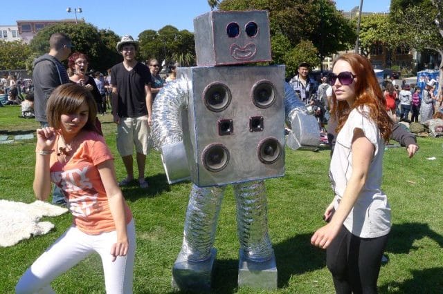 a person and a girl posing with a robot
