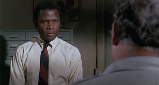 Sidney Poitier in a tie looking at another man
