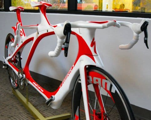 a white bicycle with a red seat