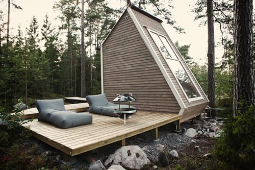 a cabin with a picnic table and chairs in the woods