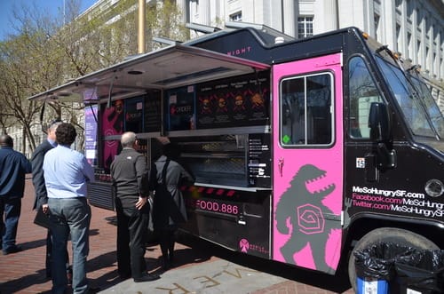 people standing next to a food truck