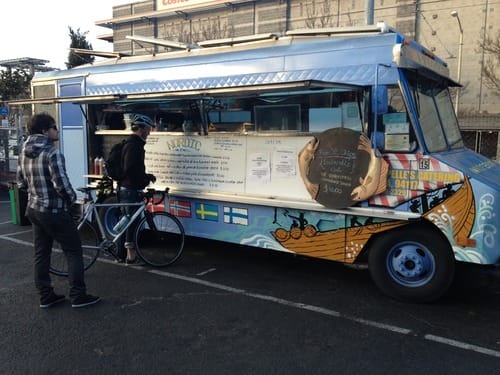 a person standing next to a food truck