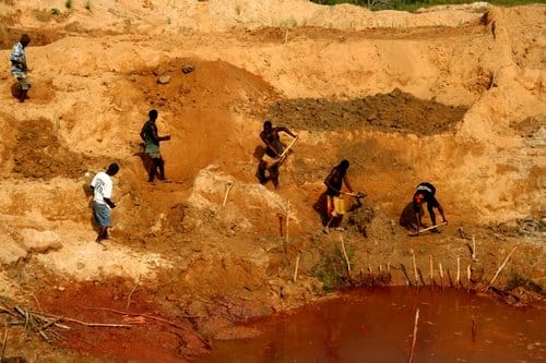 a group of people working in a muddy area
