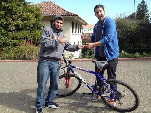 a person holding a bicycle next to a person holding a bike