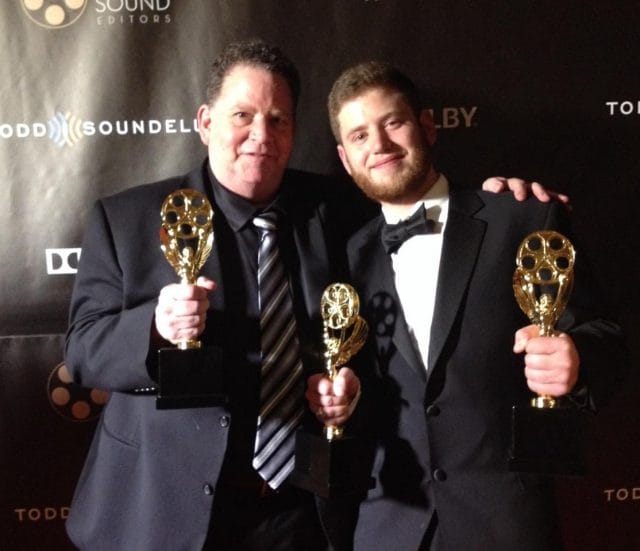 two men holding trophies