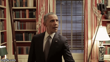 Barack Obama in a suit in a room with bookshelves